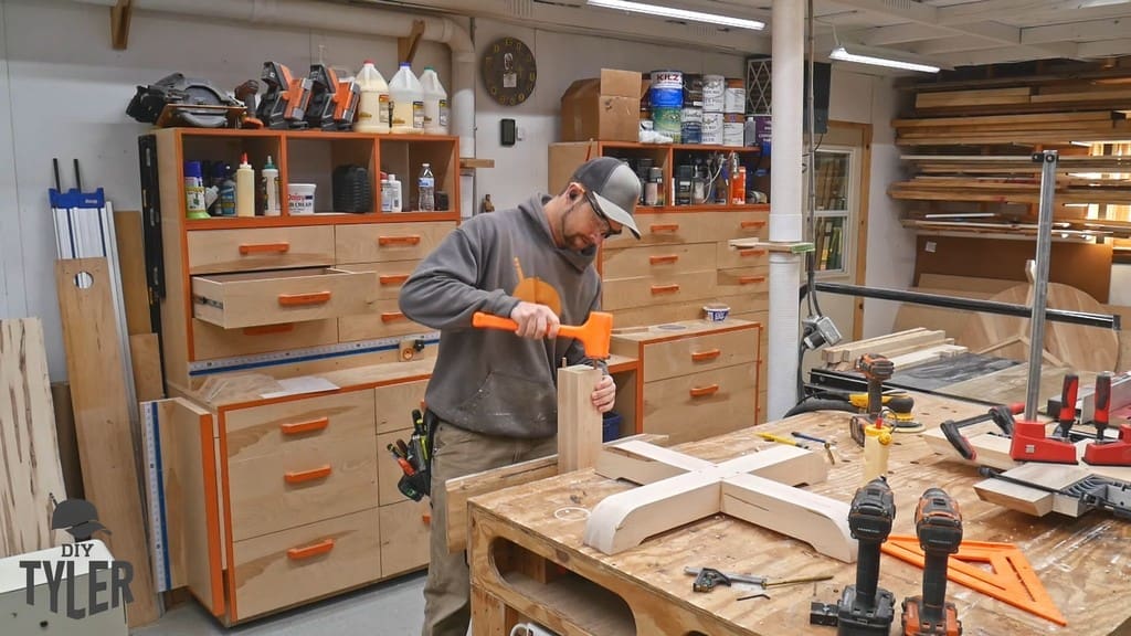 man installing dowels into table pedestal piece