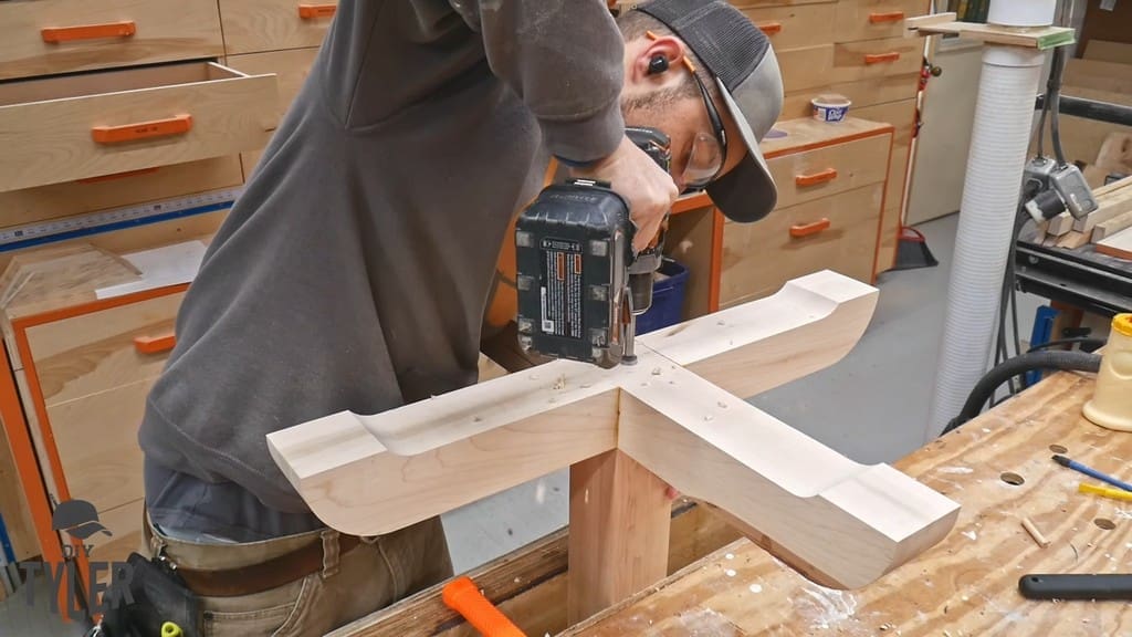 man drilling countersink hole into base and pedestal pieces