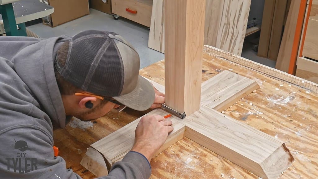 man marking out drill holes in game table pedestal piece