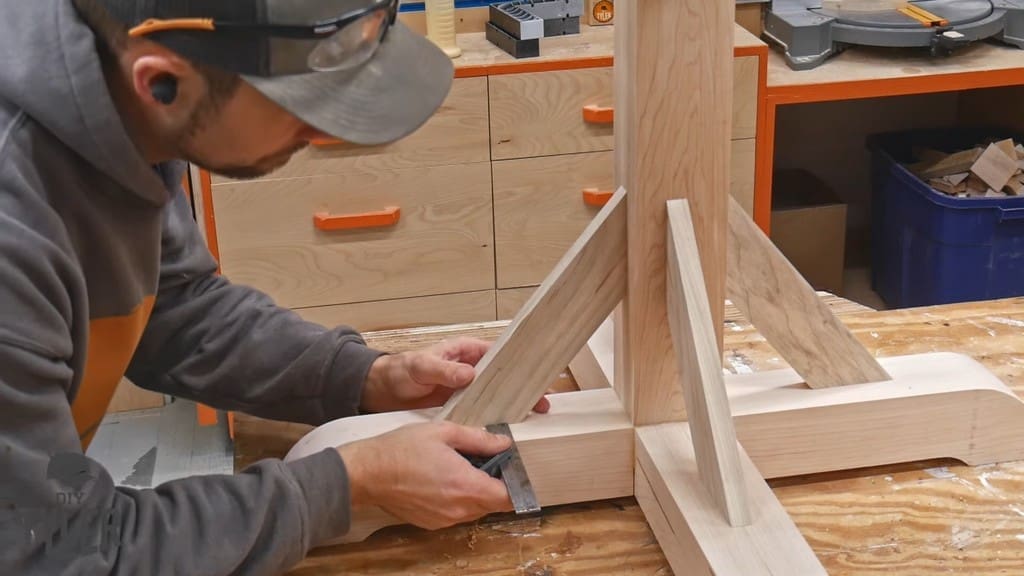 man checking positioning of brace pieces for game table pedestal pieces