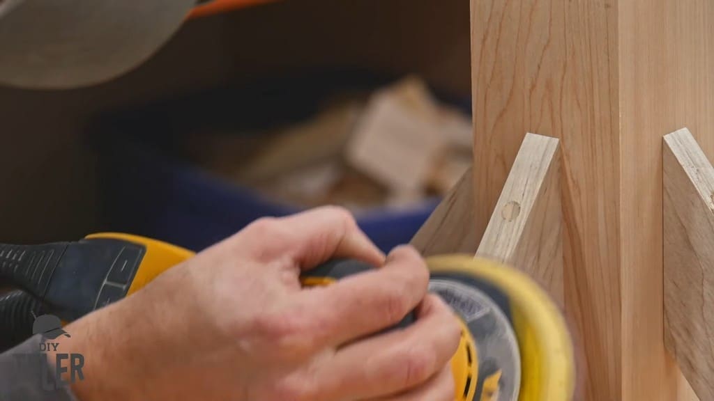 man sanding maple plug for game table brace piece