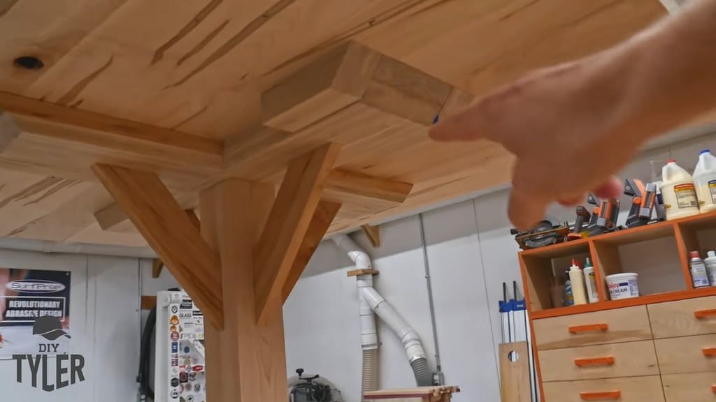 man pointing to removable section of pedestal game table