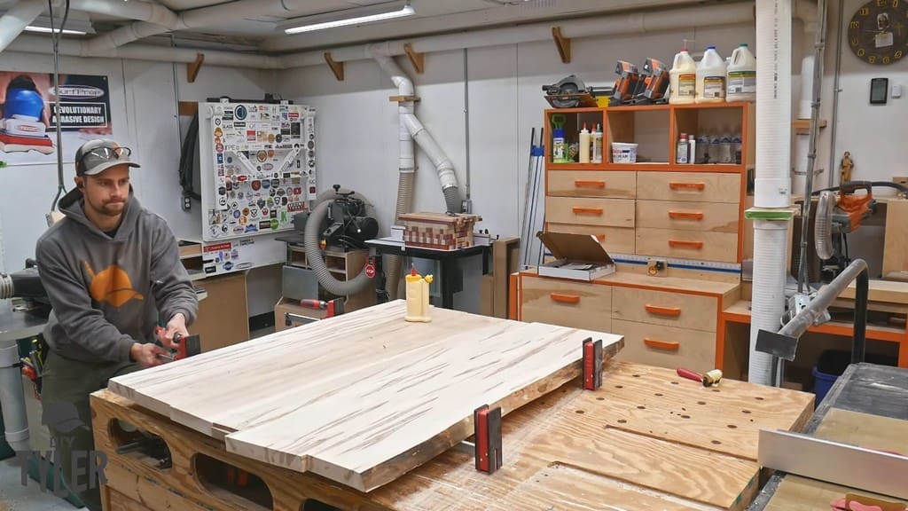 man applying clamps to maple wood slabs for tabletop