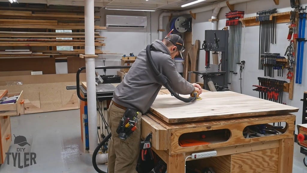 man sanding top of slab table for pedestal game table