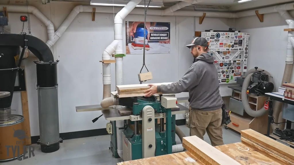 man running maple wood pieces through planer