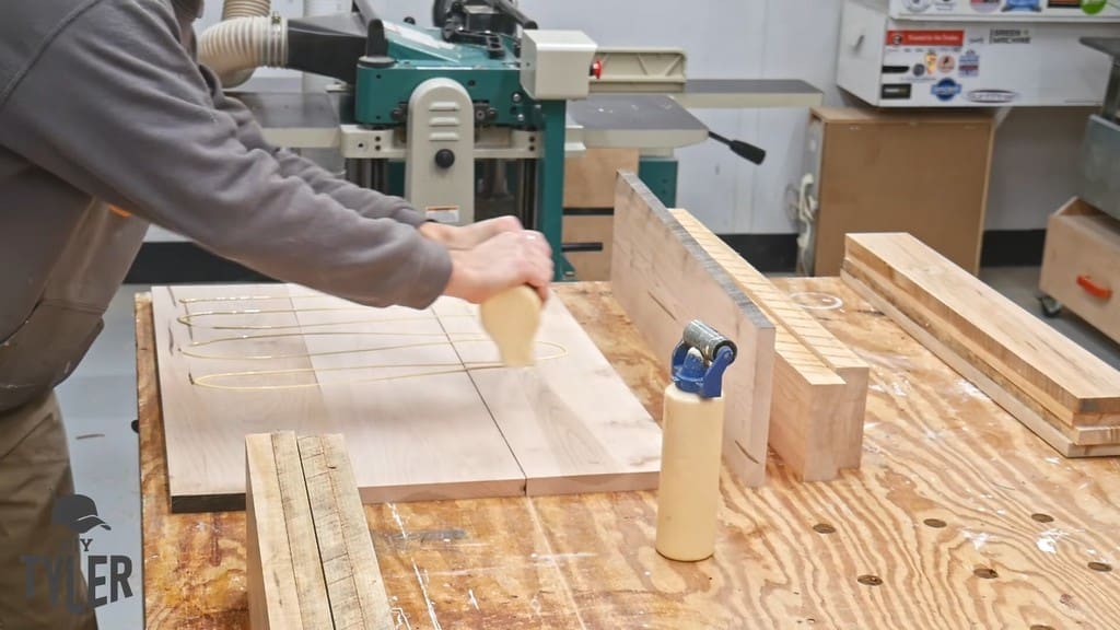 man applying Titebond II glue to maple wood pieces