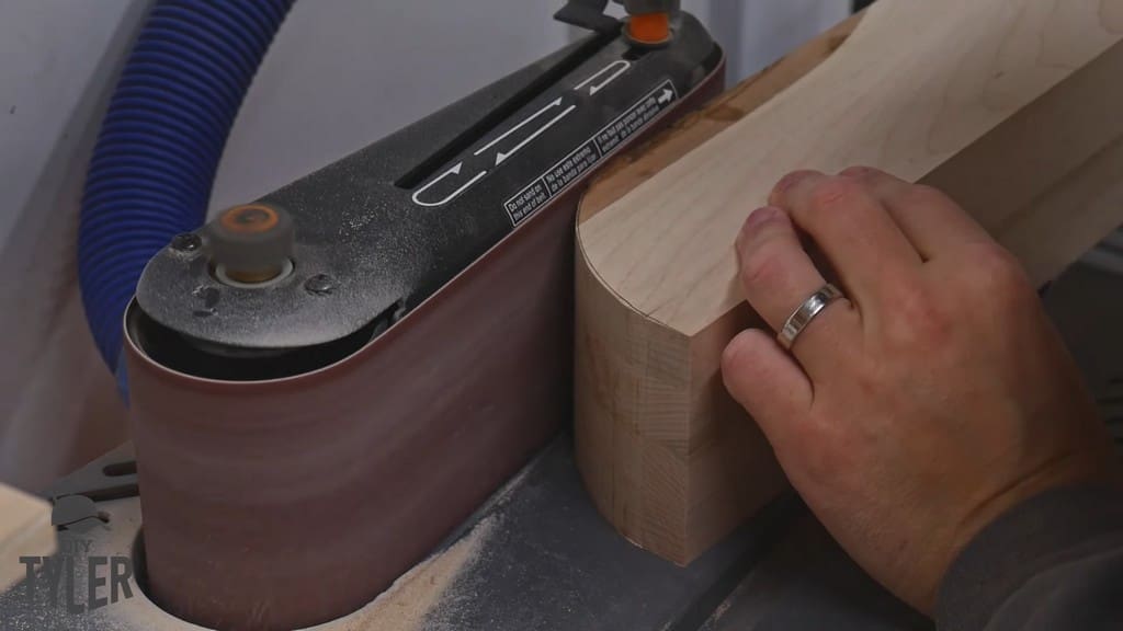 man smoothing out curved edge with RIDGID belt sander
